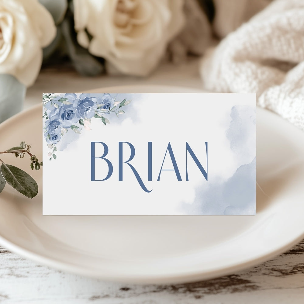 Place card with 'BRIAN' on a floral design, set on a marble surface with flowers in the background.