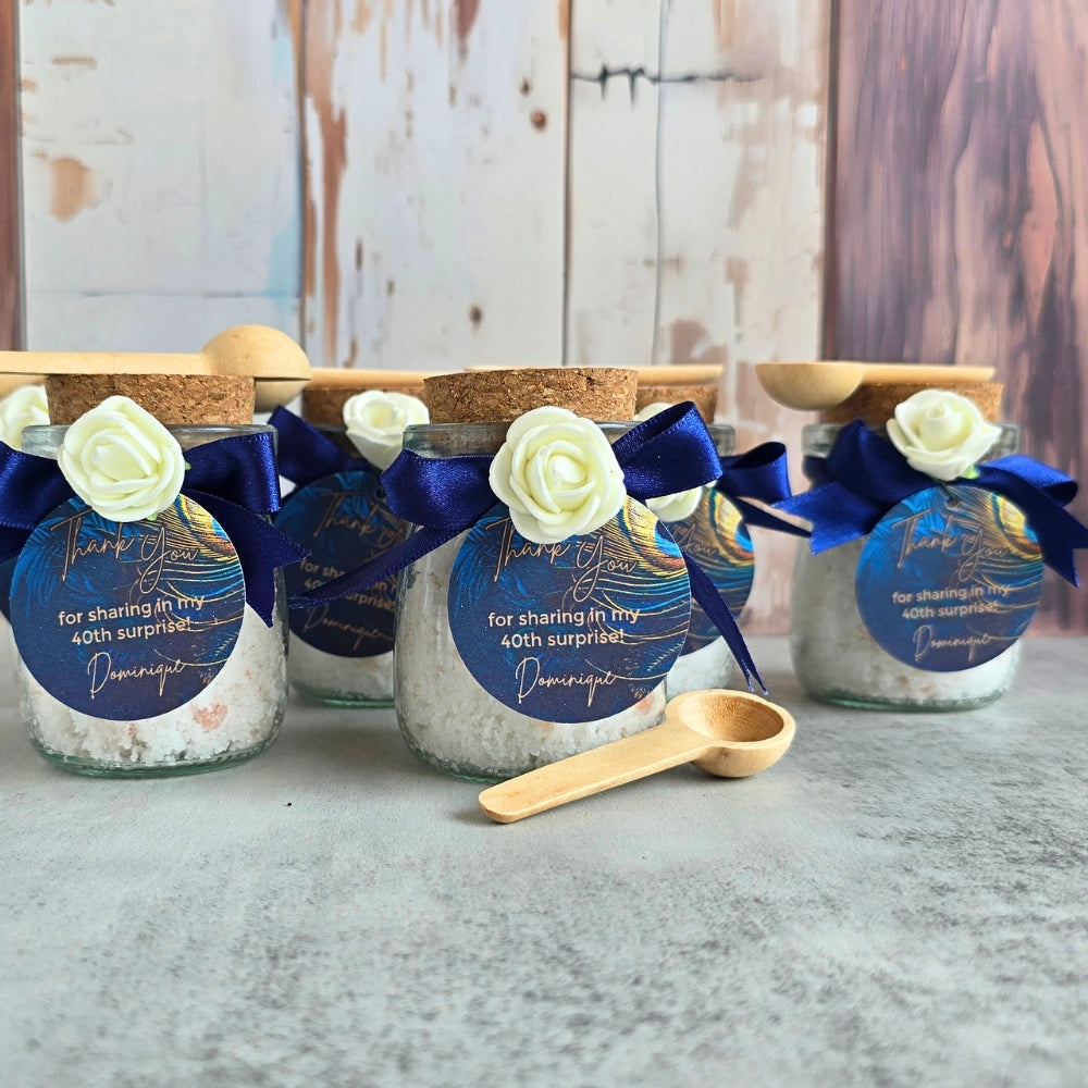 Glass jars with bath salts decorative labels and ribbons on a wooden surface