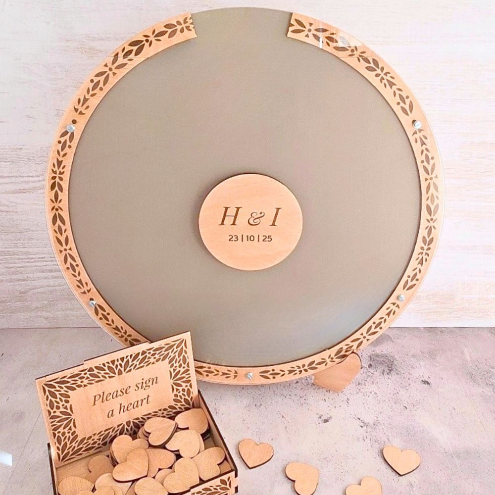 Round wooden dropbox with decorative border and 'H&I' stamp, accompanied by a box of heart-shaped wooden pieces.