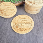 a set of wooden coasters with the names "Gabor AND Kerenga" engraved on them. The coasters are placed on a wooden surface, and there are additional coasters stacked nearby.