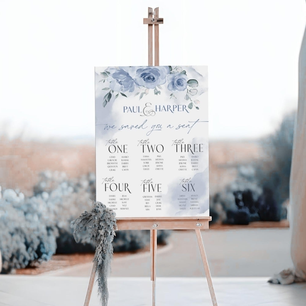 Wedding seating chart on an easel with floral design and 'Paul & Harper' text.