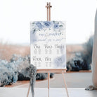 Wedding seating chart on an easel with floral design and 'Paul & Harper' text.