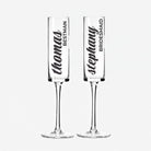 Two clear glass goblets with personalized names printed on them.