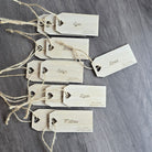 a collection of wooden name tags with names and dates printed on them, arranged on a wooden surface.