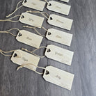 a collection of wooden name tags with names written on them, arranged on a wooden surface.