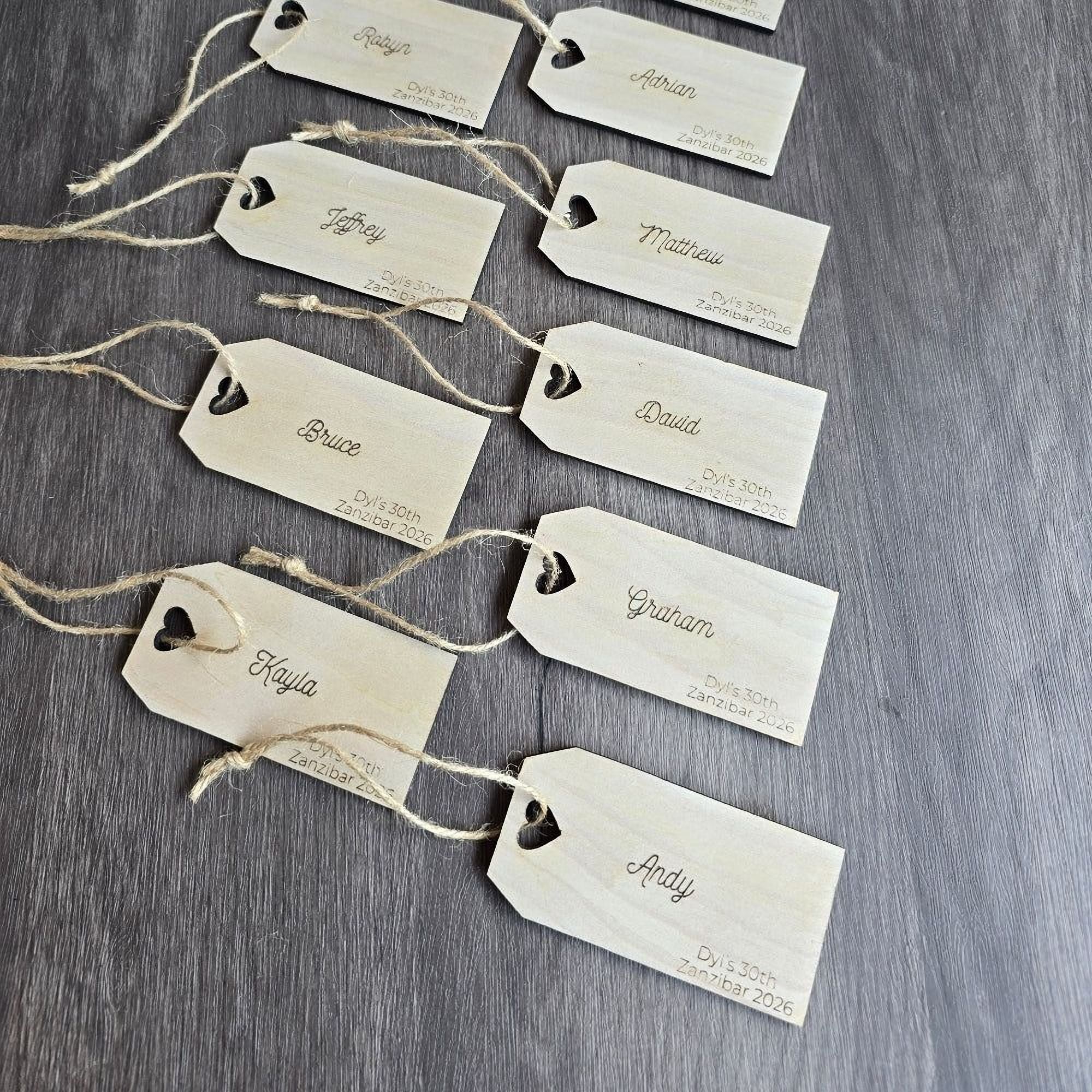 a collection of wooden name tags with names written on them, arranged on a wooden surface.