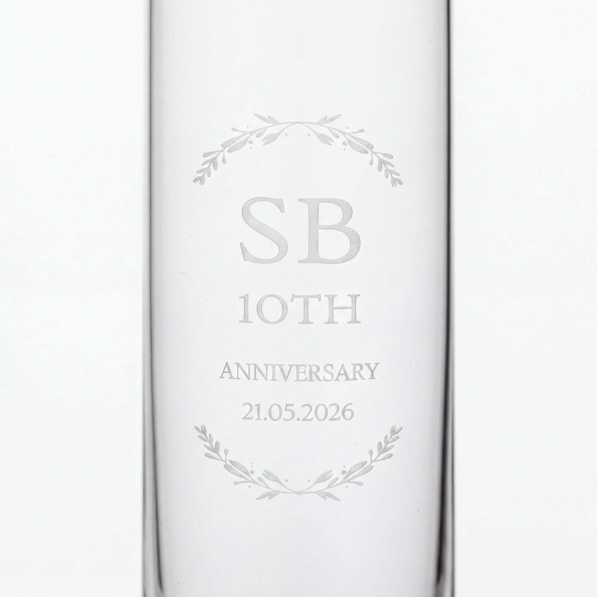 a clear glass with the text "SB 10th ANNIVERSARY 21.05.2026" engraved on it.
