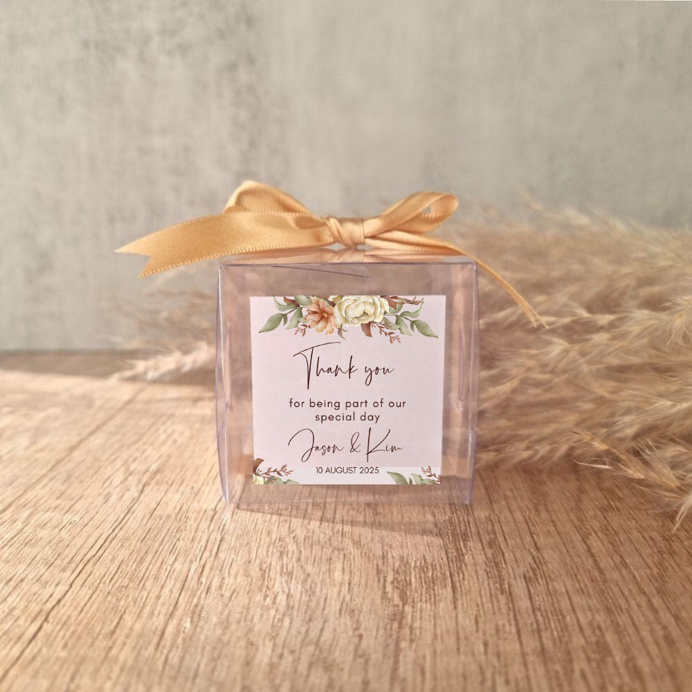 transparent favour boxes with a custom sticker and ribbon