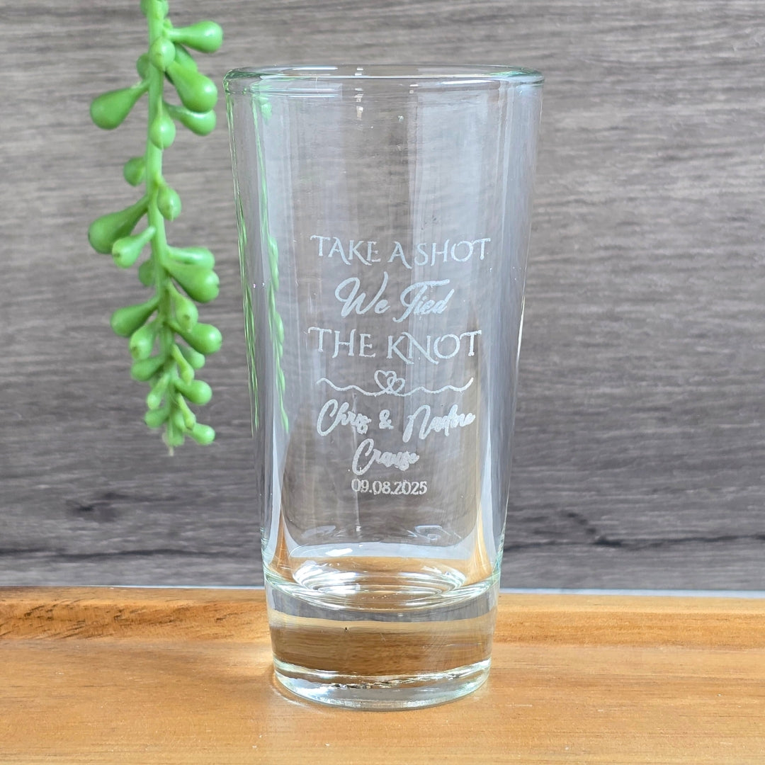 Clear shot glass with engraved silver filled text 