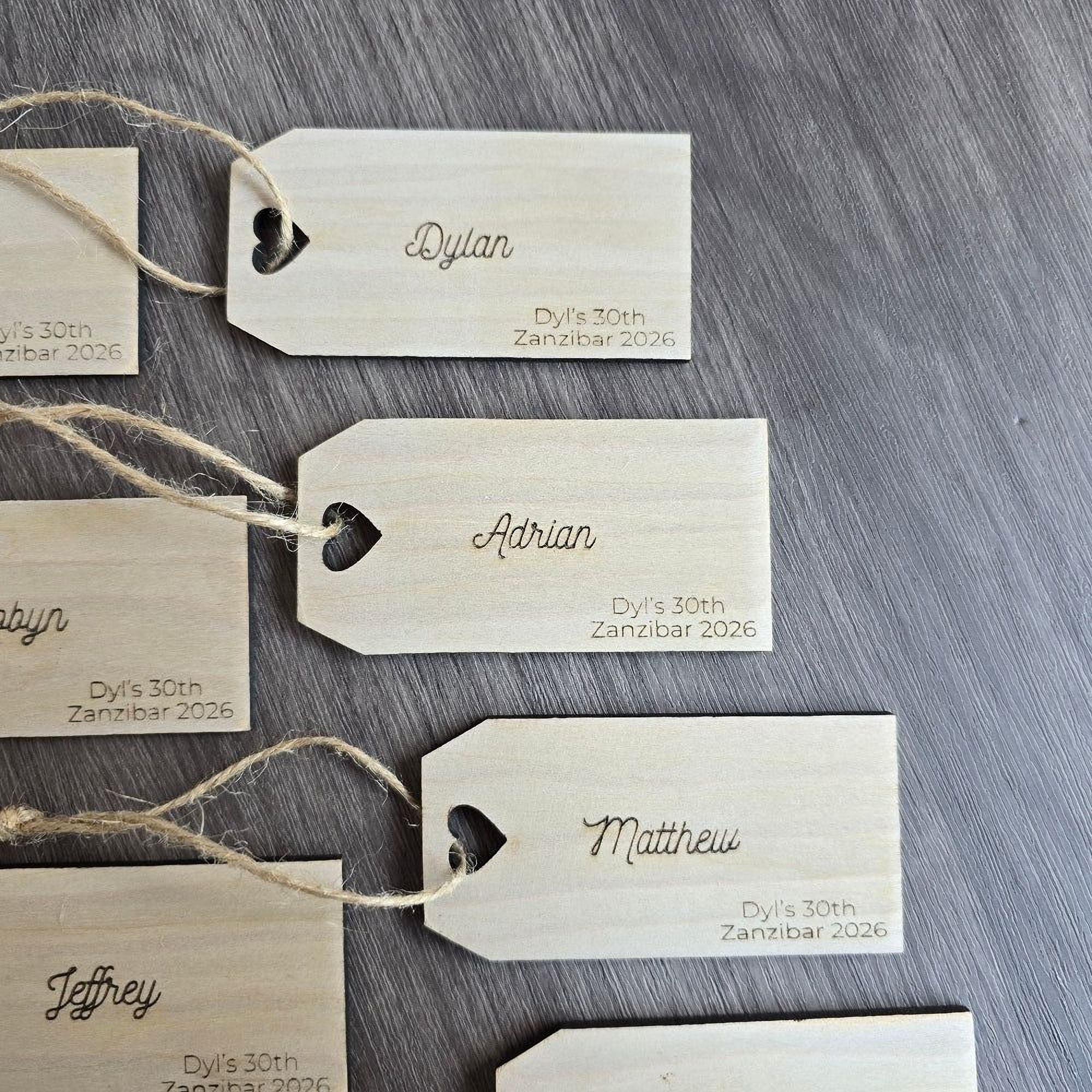 several wooden name tags with names and dates printed on them, attached to a wooden surface.