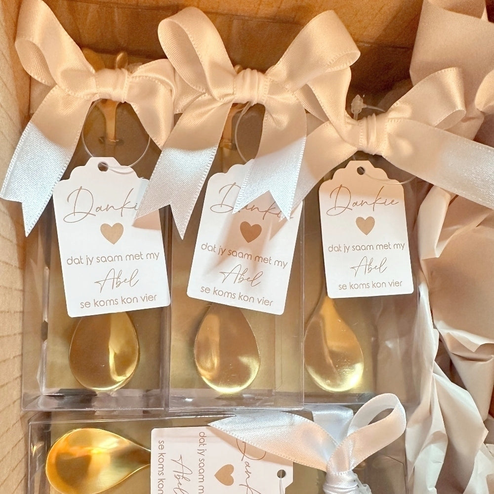 Packaged gold spoons with ribbons and tags