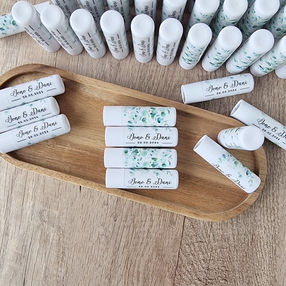 A collection of vanilla lip balm sticks displayed on a wooden tray, with the ability to be personalized with wrapped stickers.