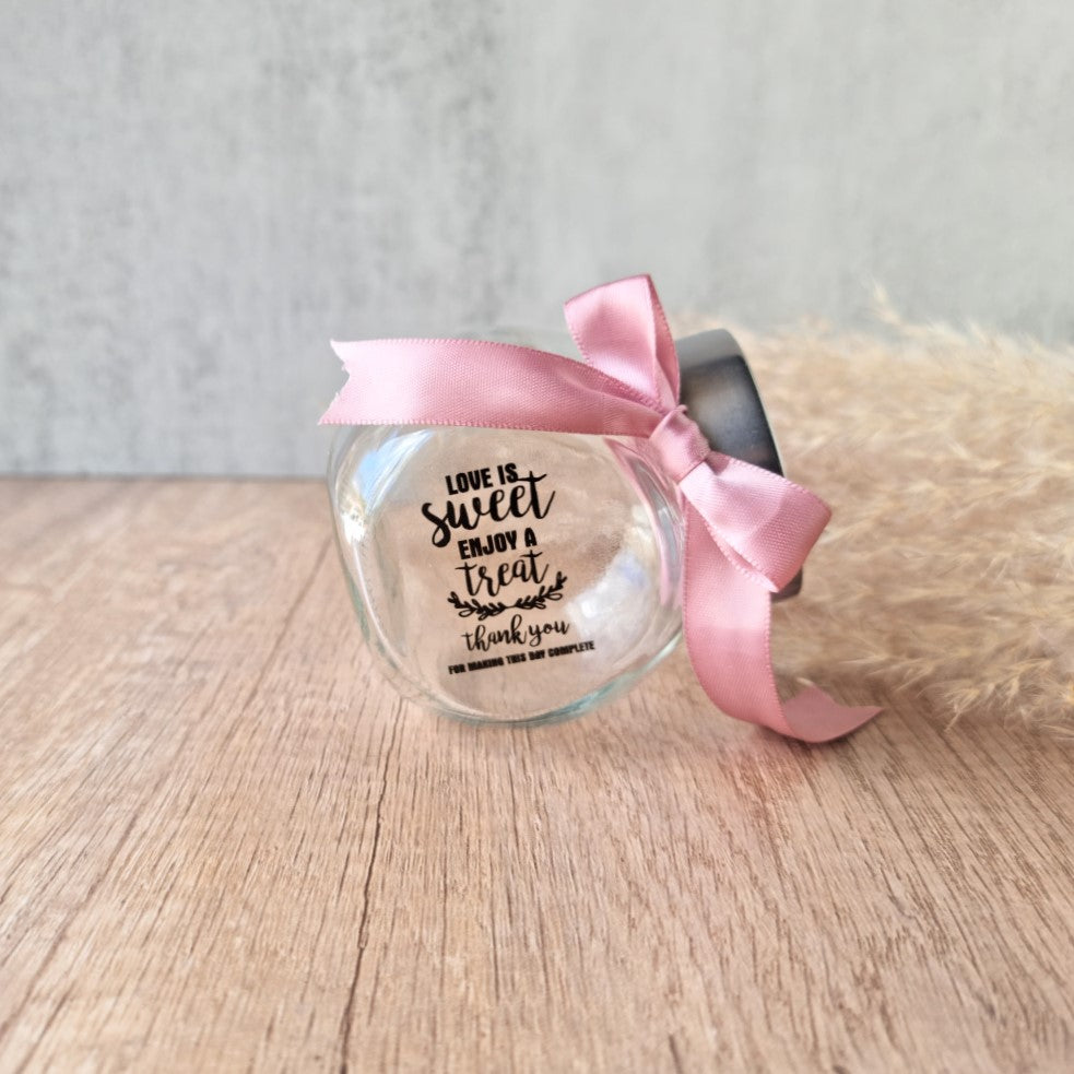 small glass candy jar with personalised sticker and ribbon
