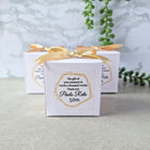 white cube shaped favour box with ribbon and sticker