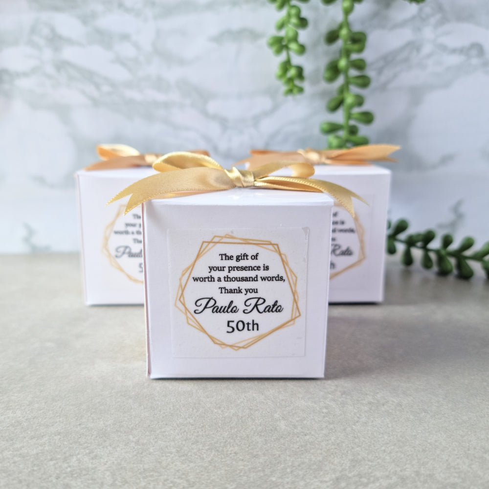 white cube shaped favour box with ribbon and sticker
